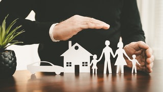 Hand über Auto, Haus und Familie