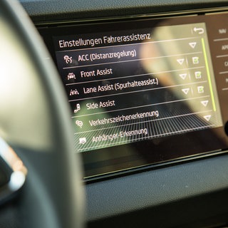 Das Infotainment-Display eines Autos zeigt verschiedene Einstellungen zu Fahrerassistenzen an. | Fahrlehrer: Fahrassistenzsysteme sind "Fluch und Segen" zugleich