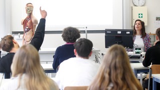 Ein Kind meldet sich im Klassenzimmer. Schülerinnen und Schüler denken laut einer neuen Studie, KI sei schlauer als ihre Lehrkräfte.