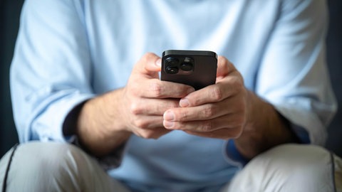 Ein Mann tippt auf einem Smartphone | Wie Betrüger bei Schockanrufen vorgehen und wie man sich schützen kann
