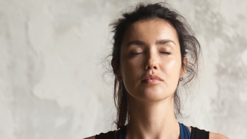 Frau macht Gesichtsyoga
