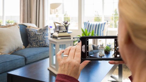Frau macht Bild vom Wohnzimmer