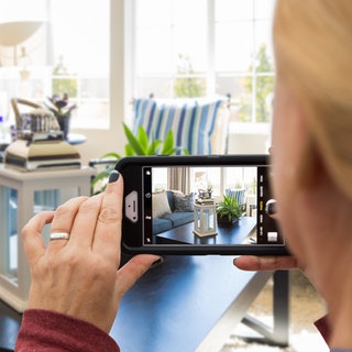 Frau macht Bild vom Wohnzimmer