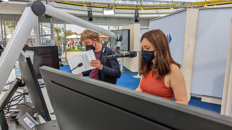 Moderationsduo beim Maimarkt auf der Bühne im Gläsernen Studio.