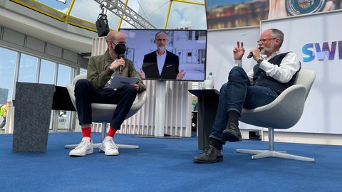 Werner Eckert, Chef der SWR-Umweltredaktion, zu Besuch im Gläsernen Studio auf dem Maimarkt bei Moderator Pascal Lassere.