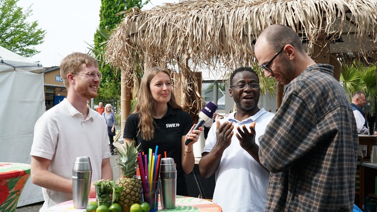 Drei SWR-Volontär*innen auf dem Maimarkt bei einer Cocktail-Challenge 
