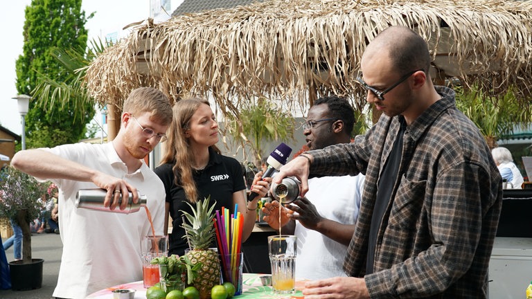 Drei SWR-Volontär*innen auf dem Maimarkt bei einer Cocktail-Challenge 
