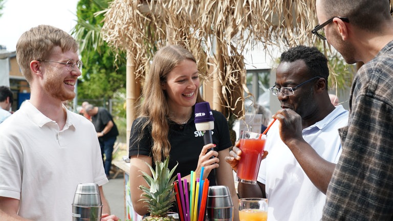 Drei SWR-Volontär*innen auf dem Maimarkt bei einer Cocktail-Challenge 