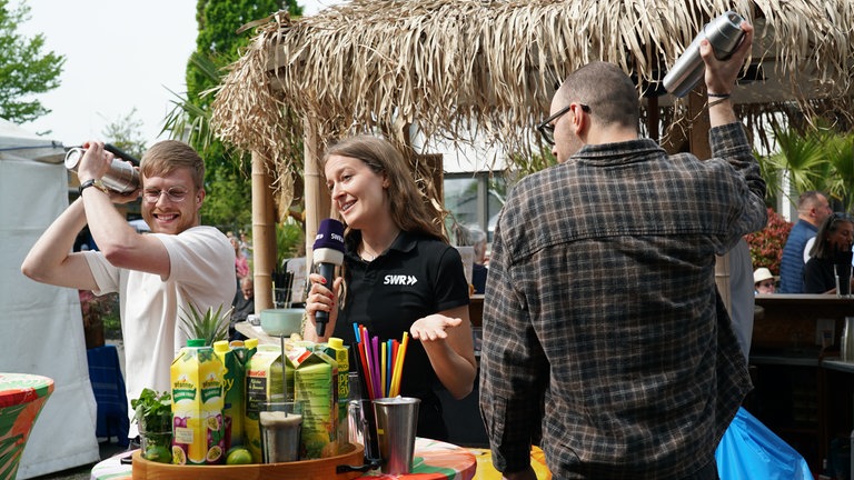 Drei SWR-Volontär*innen auf dem Maimarkt bei einer Cocktail-Challenge 