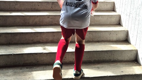 Junger Fan des 1. FC Kaiserslautern läuft Stufen empor. 