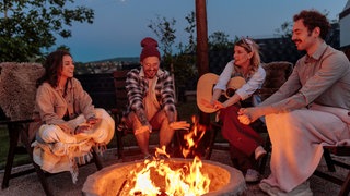 Gemeinsam am Feuer in der Nacht gegen die Einsamkeit
