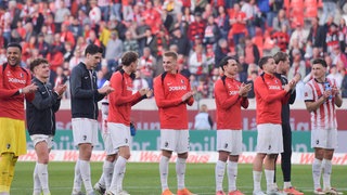 Die Spieler des SC Freiburg bedanken sich nach dem Spiel gegen Bayer 04 Leverkusen bei ihren Fans
