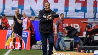 Frank Schmidt, Trainer des 1. FC Heidenheim, schaut vor dem Spiel bei Borussia Mönchengladbach auf seine Armbanduhr.