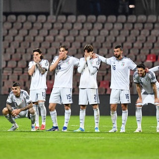 Die italienischen Spieler stehen Arm in Arm und reagieren auf das Elfmeterschießen im Play-Off-Finale