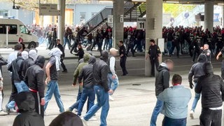 Polizisten (hinten M) gehen gegen vermummte, gewaltbereite Fans vor. Rivalisierende Fußballfans des VfB Stuttgart und des FC Bayern München haben sich eine Massenschlägerei geliefert.