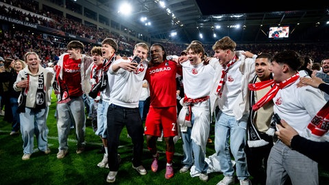 Freiburger Fans jubeln nach Einzug ins Europa-League-Finale mit Cyriaque Irie auf dem Platz