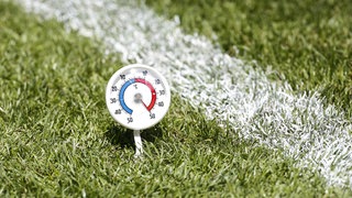 Thermometer auf einem Fußballfeld zeigt 50 Grad Celsius in der Sonne an.
