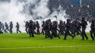 Polizisten stürmen auf den Rasen im Stadion von Waldhof Mannheim