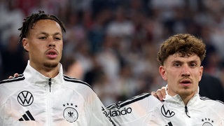 Derry Scherhant und Philipp Treu singen die Nationalhymne
