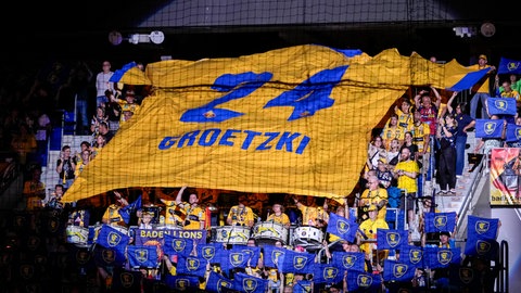 Fans der Rhein-Neckar Löwen ziehen ein großes Trikot mit der Nummer 24 zu Ehren von Patrick Groetzki auf die Tribüne
