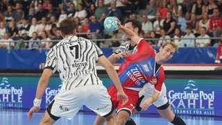 Julian Köster (THW Kiel) im Zweikampf mit Mathias Larson (SG BBM Bietigheim)