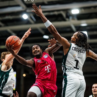 John Michael Wright (Telekom Baskets Bonn) im Zweikampf mit Marco Hollersbacher (Gladiators Trier) und Austin Crowley (Gladiators Trier), 