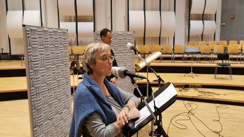 Eine Frau und ein Mann singen in ein Mikrofon