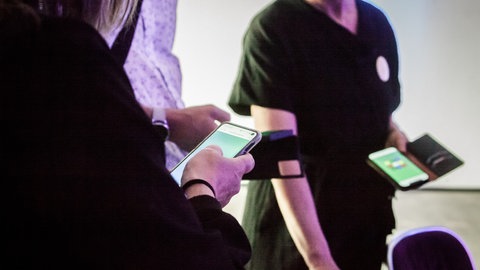 Das Publikum wandelt im Konzert mit seinen Handys umher.