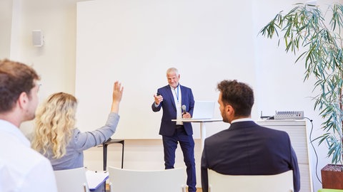 Redner gibt Präsentation bei Business Konferenz vor Publikum im Konferenzraum