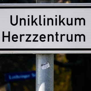 Ein Schild mit Richtungspfeil zum Uniklinikum Herzzentrum steht an einer Straße