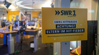 Schild mit der Aufschrift Eltern im Hit-Fieber