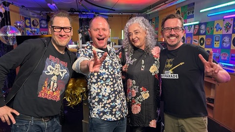 Jochen Stöckle, Annett Lorisz, Patrick Neelmeier und Ingo Lege stehen in einer Gruppe zusammen im Studio und freuen sich. 