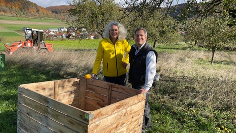 Katrin Kleinbram und Platzansager Martin stehen auf einer Streuobstwiese in der Sonne