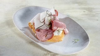 Schäufele-Stulle mit Apfel-Meerettich-Creme und schwarzem Rettich auf einem Teller. Ein SWR1 Pfännle-Rezept zum Motto "Bock auf Brot".