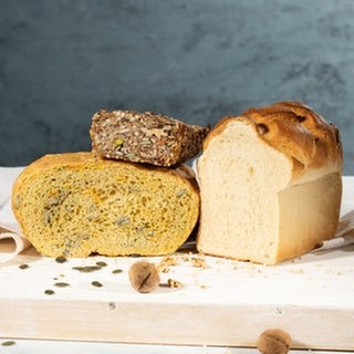 Körner-Nüsse-Saaten-Brot, Kürbis-Topfbrot und Toastbrot auf einem Schneidebrett. SWR1 Pfännle-Rezepte zum Motto "Bock auf Brot".