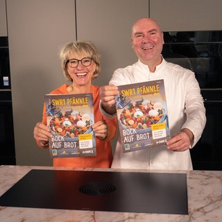 SWR1 Moderatorin und SWR1 Pfännle-Koch Eberhard Braun halten das neue SWR1 Pfännle-Magazins 2026 mit Rezepten zum Motto "Bock auf Brot".