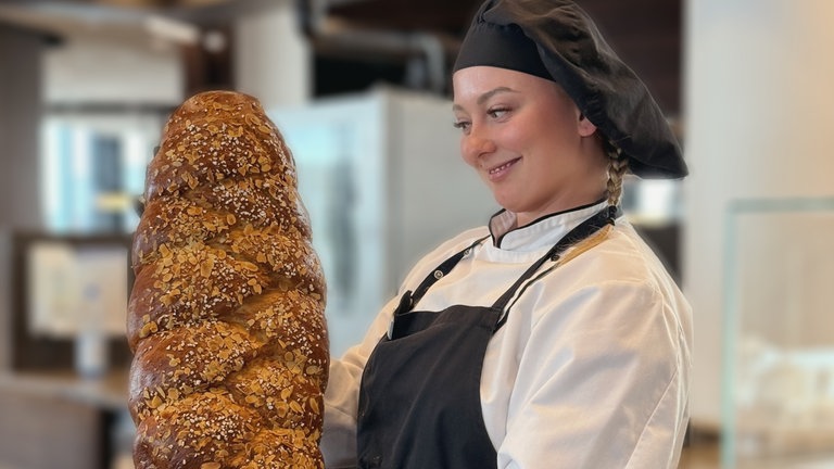 SWR1 Pfännle-Konditorin Mariia Serhiichuk betrachtet stolz ein großes Brot.