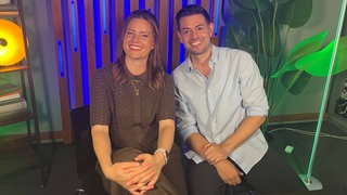 SWR1 Moderatorin Cora Klausnitzer und SWR1 Moderator Matthias Sziedat sitzen nebeneinander.