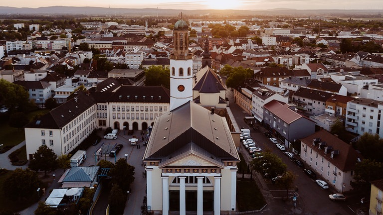 Drohnenaufnahme: Die Innenstadt von Frankenthal mit der Zwölf-Apostel-Kirche bei abendlicher Stimmung.