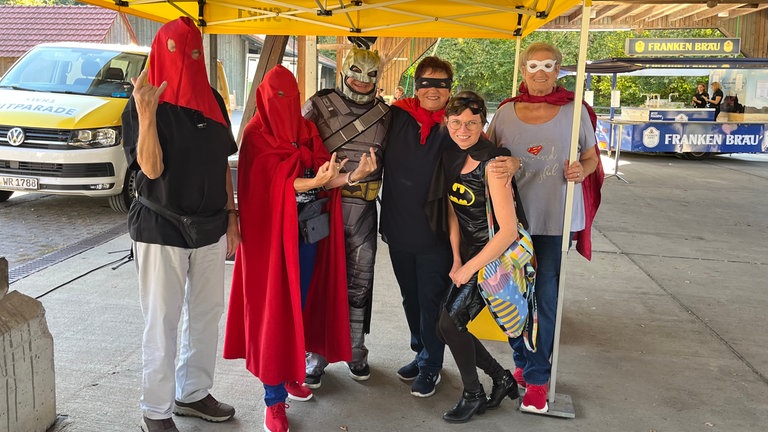Tag 2 beim SWR1 HITmach-Duell: Benedict Walesch sucht in Niederstetten im Main-Tauber-Kreis zum Song "Holding Out For A Hero" von Bonnie Tyler Superhelden. Josef und Ronja basteln sich mit Mama Christina Superhelden-Masken aus Papier.