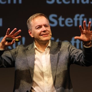 Kabarettist Steffen Möller performt auf einer Bühne. Kabarettist Steffen Möller blickt auf unser Verhältnis mit Polen wie "Alfons" auf das mit Frankreich. Mit liebevoller Ironie macht er augenzwinkernde Beobachtungen über Unterschiede und Gemeinsamkeiten – wie in "Viva Polonia" und "Polnische Paartherapie". Über sein Leben zwischen Deutschland und Polen, über Gemeinsamkeiten und Unterschiede mit unseren Nachbarn im Osten und die aktuelle Politik in Polen sprechen wir mit Steffen Möller in SWR1 Leute.