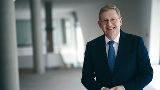 Oliver Barta, Hauptgeschäftsführer von Südwestmetall, lacht in die Kamera. Er ist zu Gast in SWR1 Leute und spricht über die Zukunft des Wirtschafststandorts Baden-Württemberg. Wird Baden-Württemberg ein Schwerpunktland der europäischen Rüstungsproduktion? Was erwarten die Wirtschafsverbände von der Regierung unter Kanzler Merz?