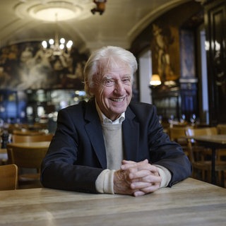 Der Schweizer Kabarettist Emil Steinberger sitzt im Restaurant an einem Tisch. Spätestens seit den 70er Jahren gehört Emil Steinberger fest zur Spitze des deutschsprachigen Kabaretts. Sein Humor und seine Sprache prägten Generationen. Legendär sein Sketch mit dem "Bömbli" und dem "Schäufeli" - und natürlich das berühmte "Ogtern". Er ist zu Gast in SWR1 Leute.