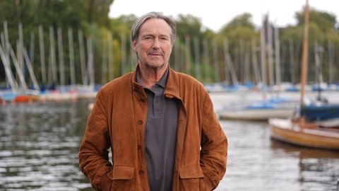 Schauspieler Helmut Zierl steht an der Außenalster am Bootsanleger des Restaurants Bobby Reich.