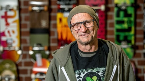 Titus Dittmann lächelt in die Kamera. Das Skateboard hat das Leben von Titus Dittmann komplett verändert: Der ehemalige Lehrer wurde zum Wegbereiter eines neues Sports. Mit seiner Organisation "skate-aid" baut er mittlerweile weltweit Skateparks für Kinder. In SWR1 Leute erzählt er, wie aus dem vermeintlich kurzfristigen Trend eine Bewegung wurde.