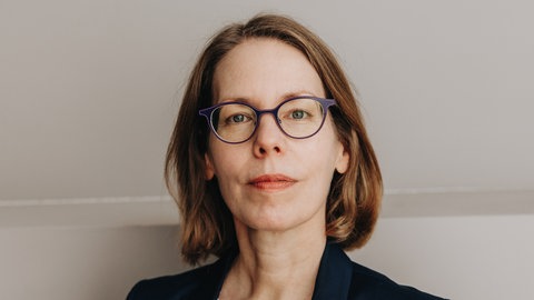 Anne Brorhilker, ehemalige Staatsanwältin, blickt in die Kamera. Sie spricht über den Kampf gegen Wirtschaftskriminalität.