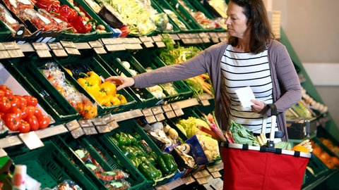 Frau kauft in der Obst- und Gemüseabteilung eines Supermarktes ein. Supermärkte und Discounter beschäftigen Stephan Rüschen in SWR1 Leute. Wie kommt der Preis zustande? Welche Rolle spielen Apps und ist Bio noch immer im Trend?