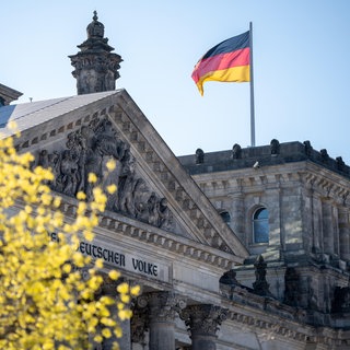 Deutsche Flagge weht am Reichstagsgebäude. Politologe Christian Stecker fordert ein Umdenken in den Parlamenten. Mit Brandmauern sollte die Politik konstruktiver umgehen, sich die Mehrheiten für Vorhaben flexibel und an den Sachthemen orientiert holen. Was genau er damit meint, das besprechen wir mit dem Politikwissenschaftler Christian Stecker in SWR1 Leute.