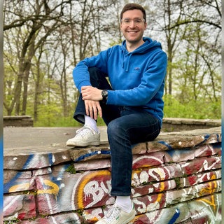 Bestsellerautor David Nelles sitzt auf einer mit Graffiti besprühten Mauer. | Wie wär's mit konkreten Lösungen? David Nelles macht Vorschläge beim Klima und anderen Streitthemen