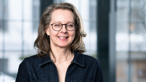 Finanzcoachin Dani Parthum schaut in die Kamera und lächelt.